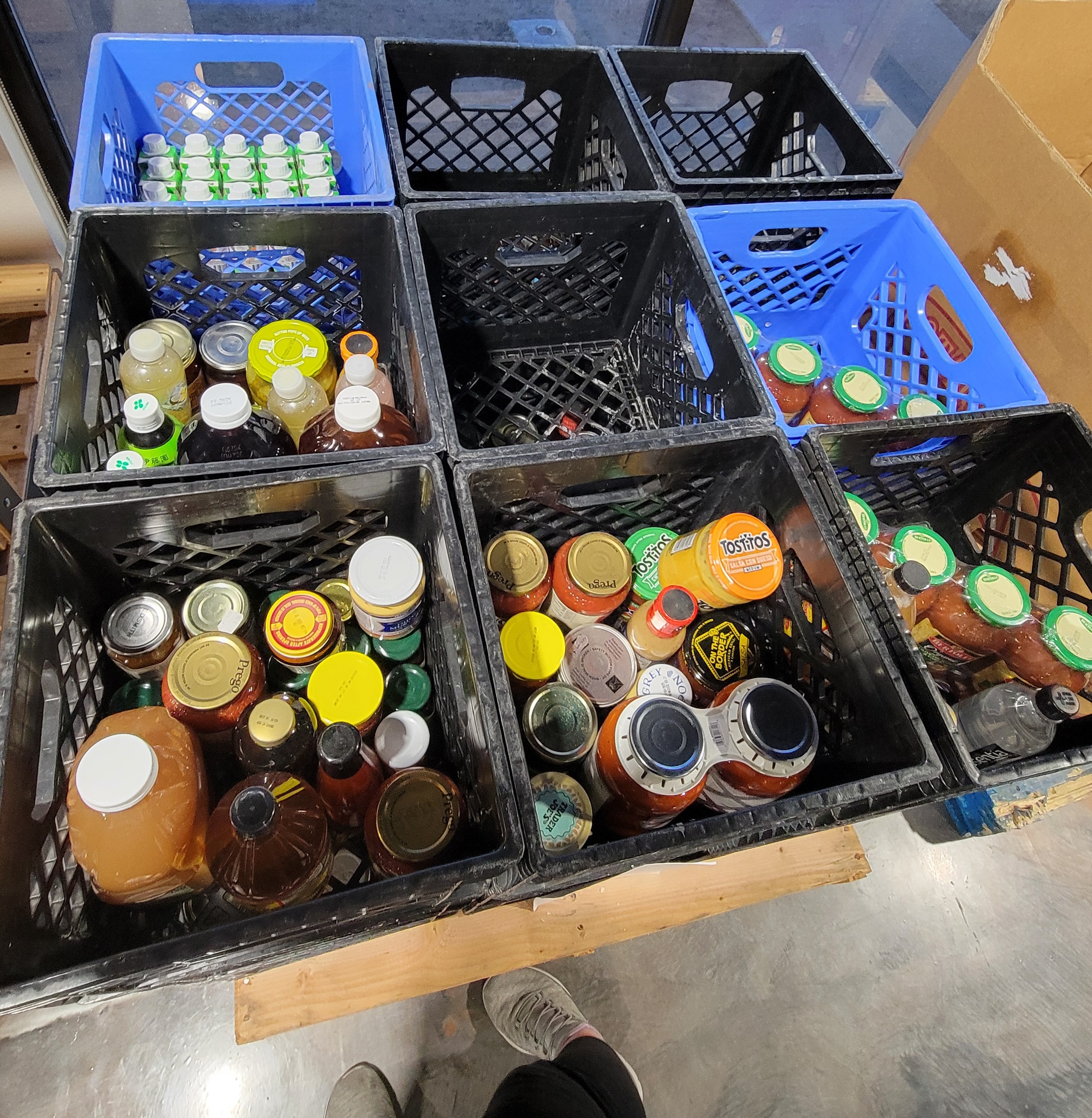 Crates on a pallet with some filled with glass jars.